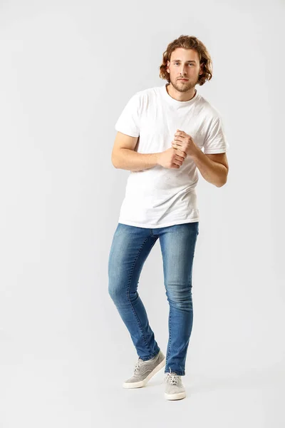 Elegante giovane uomo in jeans su sfondo bianco — Foto Stock