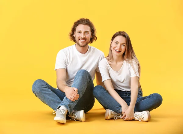 Стильная молодая пара в джинсах на цветном фоне — стоковое фото