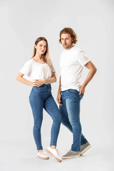 Стильная молодая пара в джинсах на белом фоне — стоковое фото