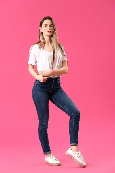 时尚年轻女子在牛仔裤的颜色背景 — 图库照片