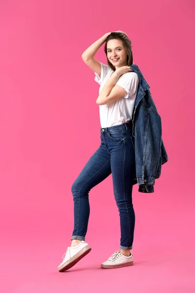Stylish young woman in jeans clothes on color background — Zdjęcie stockowe