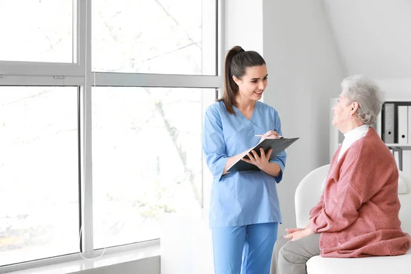 Travailleur médical examinant une femme âgée en maison de soins infirmiers — Photo