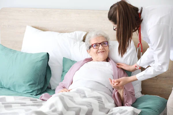 Médecin visitant une femme âgée en maison de retraite — Photo