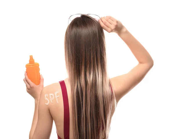 Vacker ung kvinna med flaska solskyddskräm på vit bakgrund — Stockfoto