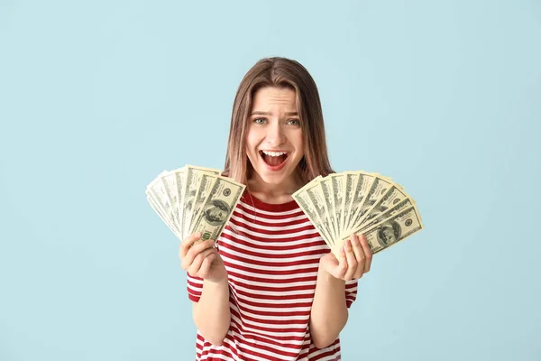 Mujer joven feliz con dinero en el fondo de color —  Fotos de Stock