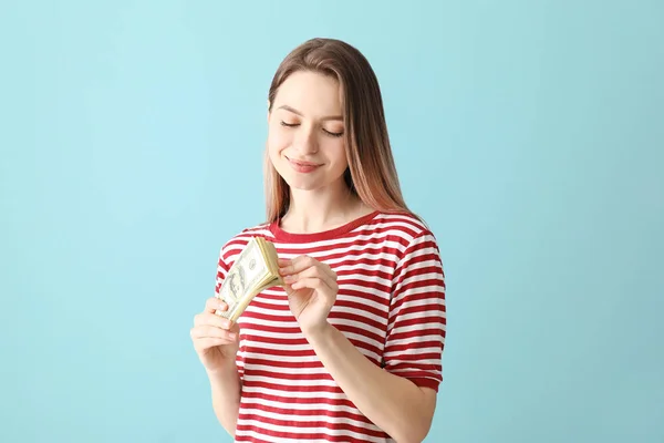 Young woman with money on color background — Stock Photo, Image