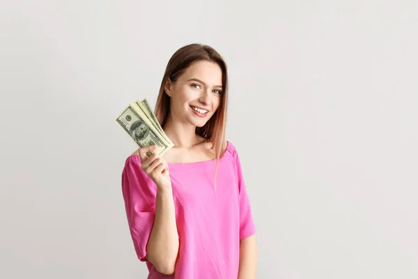 Щаслива молода жінка з грошима на білому тлі — стокове фото