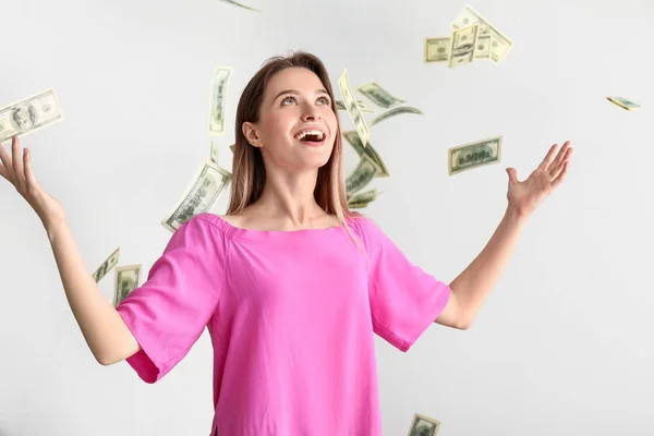 Mutlu genç kadın ve beyaz arka plan üzerinde düşen dolar banknotlar — Stok fotoğraf