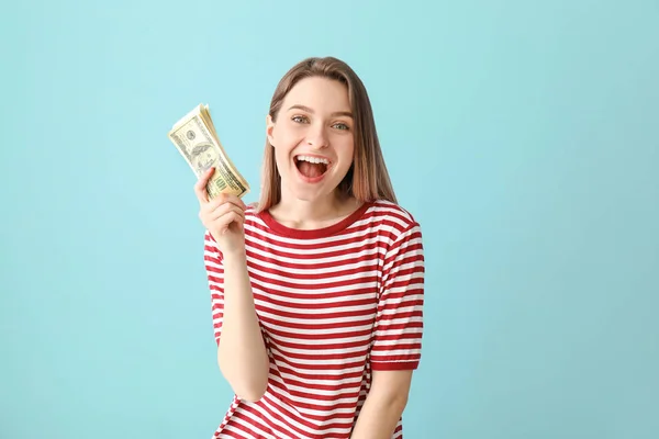 Happy young woman with money on color background — Stock Photo, Image