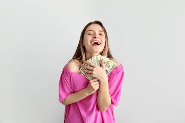 Happy young woman with money on white background