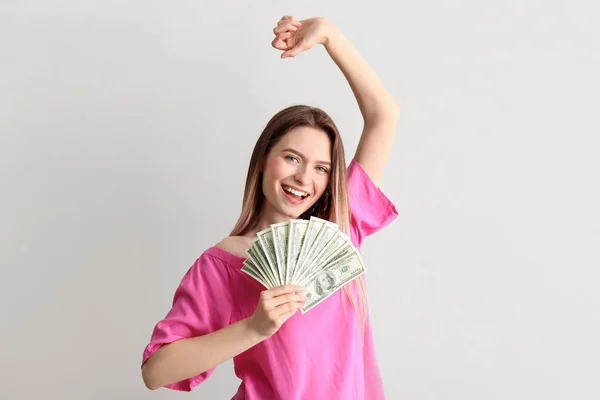 Happy young woman with money on white background