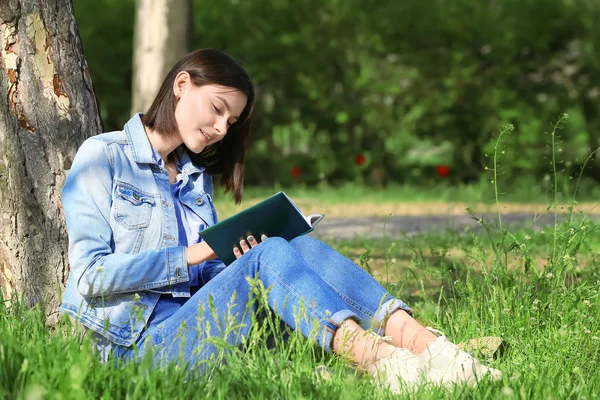 Jovem bonita leitura livro no parque — Fotografia de Stock