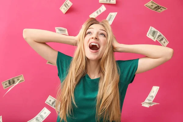 Jovem feliz e notas de dólar caindo no fundo de cor — Fotografia de Stock