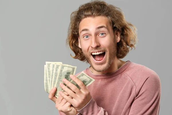 회색 배경에 돈을 가진 행복한 남자 — 스톡 사진