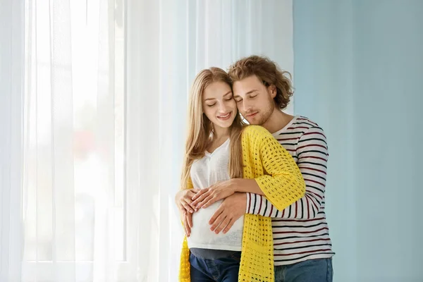 Feliz joven pareja embarazada en casa — Foto de Stock