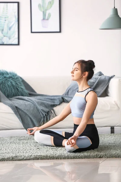 Young woman practicing yoga at home — Stock Photo, Image