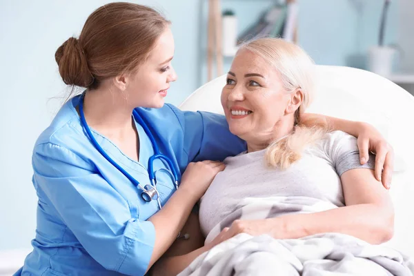 Medical assistant with mature patient in clinic — Stock Photo, Image
