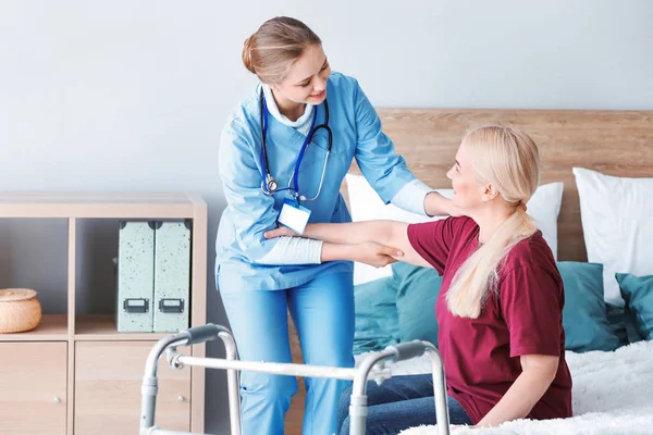 Medical assistant with mature patient at home — Stock Photo, Image