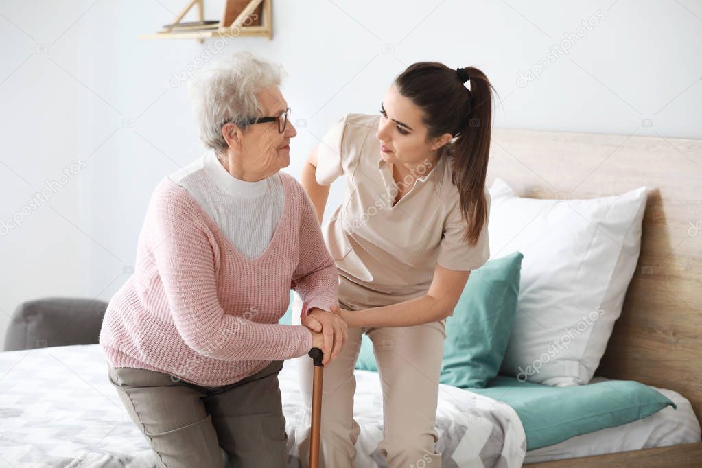 Caregiver with senior woman in nursing home