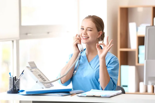 Jeune assistant médical parlant par téléphone à la clinique — Photo