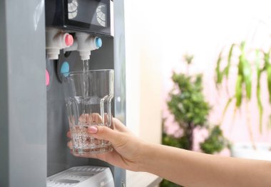 Soğutucudan cama su döken kadın