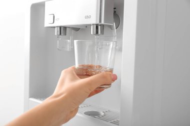 Soğutucudan cama su döken kadın