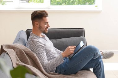 Tablet bilgisayar evde dinleniyor ile Yakışıklı adam