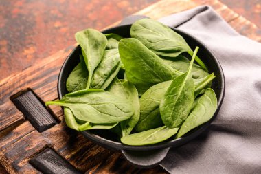 Ahşap tahta üzerinde taze ıspanak ile kızartma tavası