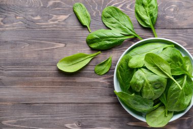 Ahşap masa üzerinde taze ıspanak ile Tabak