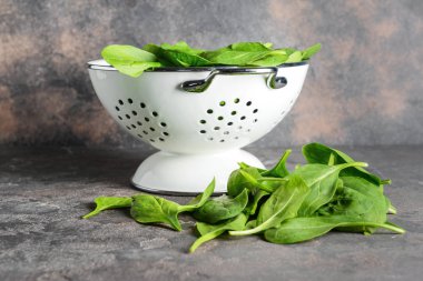 Grunge arka planda taze ıspanak ile Colander