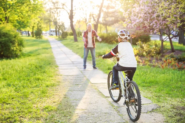 Батько навчає свого сина їздити на велосипеді на відкритому повітрі — стокове фото