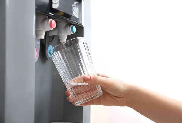 Женщина наливает воду из холодильника в стекло — стоковое фото