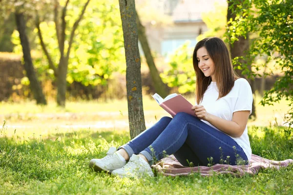 Jovem bonita leitura livro no parque — Fotografia de Stock