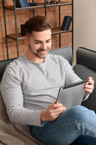 Bel homme avec tablette informatique reposant à la maison — Photo