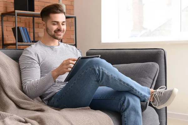 Όμορφος άντρας με tablet υπολογιστή που αναπαύεται στο σπίτι — Φωτογραφία Αρχείου