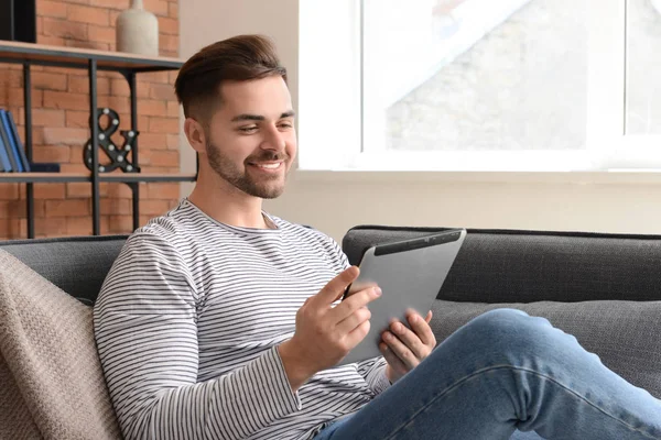 Bel homme avec tablette informatique reposant à la maison — Photo