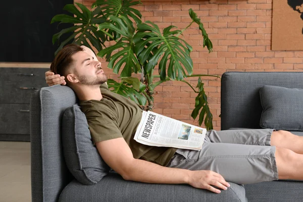 Homem bonito com jornal dormindo em casa — Fotografia de Stock