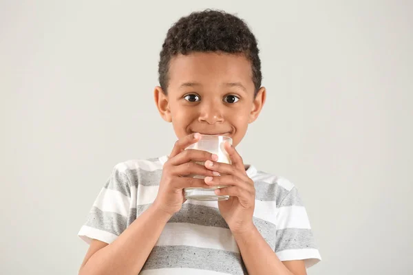Lindo chico afroamericano con vaso de leche sobre fondo blanco — Foto de Stock