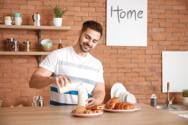 Yakışıklı adam evde mutfakta lezzetli süt içme