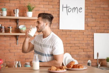 Yakışıklı adam evde mutfakta lezzetli süt içme