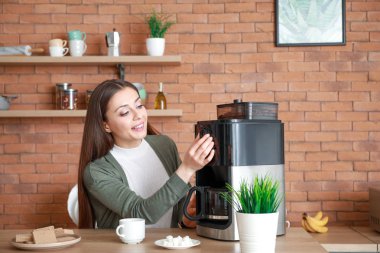Mutfakta kahve makinesi kullanan güzel kadın