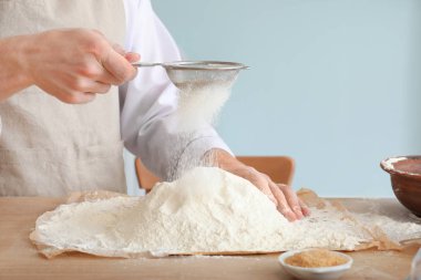 Erkek şef mutfakta un eleyen