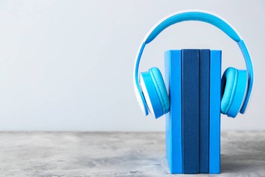 Masa üzerinde kitaplar ve modern kulaklıklar. Sesli kitap kavramı