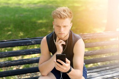 Sportif genç adam nabzını dışarıda kontrol ediyor