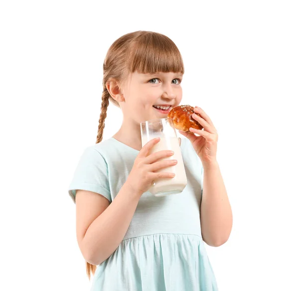 Niedliches kleines Mädchen mit Glas Milch und Brötchen auf weißem Hintergrund — Stockfoto