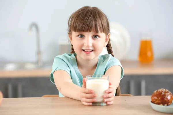 Aranyos kislány, egy pohár tej asztalnál — Stock Fotó