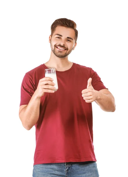 Bel homme avec un verre de lait savoureux montrant geste pouce vers le haut sur fond blanc — Photo