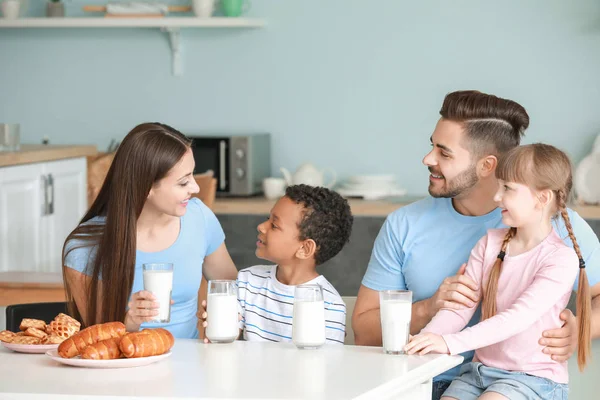 Young family drinking tasty milk in kitchen at home — Stock Photo, Image