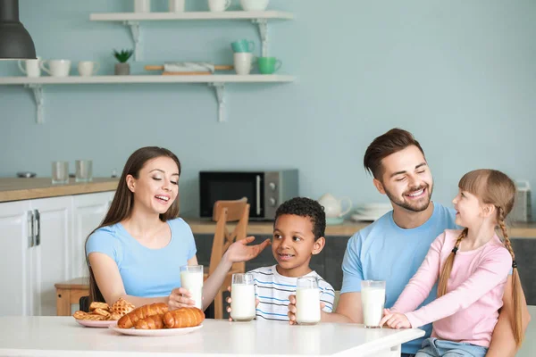 Joven familia bebiendo sabrosa leche en la cocina en casa —  Fotos de Stock