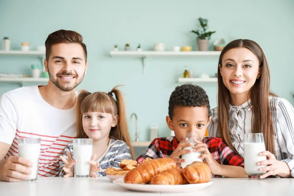 Giovane famiglia che beve gustoso latte in cucina a casa — Foto Stock